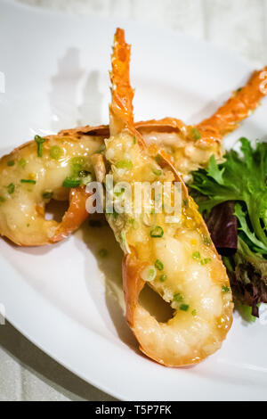 Stir fry Australian lobster with savoury sauce and spring onions and lettuce on the side Stock Photo