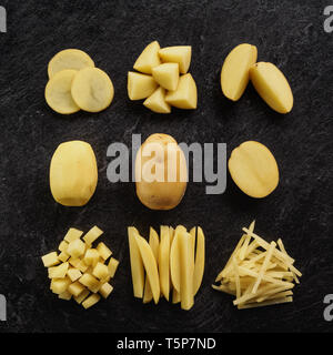 Different cuts of potatoes on a black textured background. Photo taken from above Stock Photo