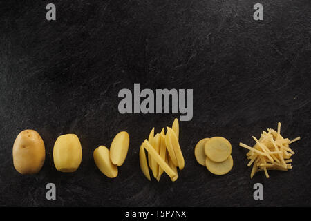 Different cuts of potatoes on a black textured background. Photo taken from above Stock Photo