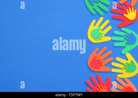 Funky foam hands of different sizes in red, orange, yellow, green and blue on a plain background Stock Photo