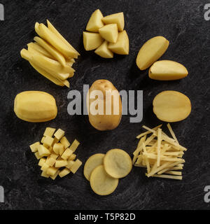 Different cuts of potatoes on a black textured background. Photo taken from above Stock Photo