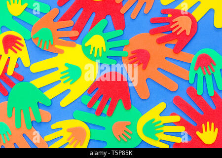 Funky foam hands of different sizes in red, orange, yellow, green and blue on a plain background Stock Photo