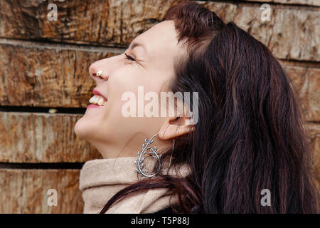Outdoor close up portrait of beautiful woman wearing silver earrings Stock Photo