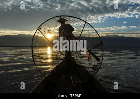 05.03.2014, Nyaungshwe, Shan State, Myanmar, Asia - A one-legged rower is paddling along the northern shore of the Inle Lake at dawn. Stock Photo