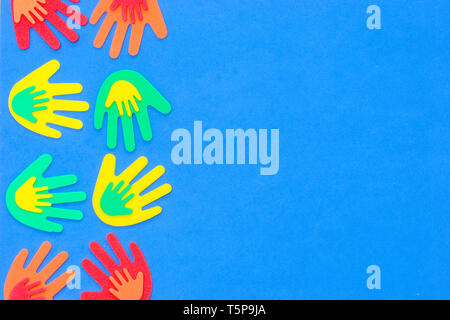 Funky foam hands of different sizes in red, orange, yellow, green and blue on a plain background Stock Photo