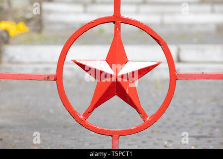 Big metal red army star symbol. Red star in circle forged in metal. Gate of Russian military cemetery. Stock Photo