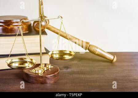 Symbols of law: wood gavel, soundblock, golden scales and two thick old books Stock Photo