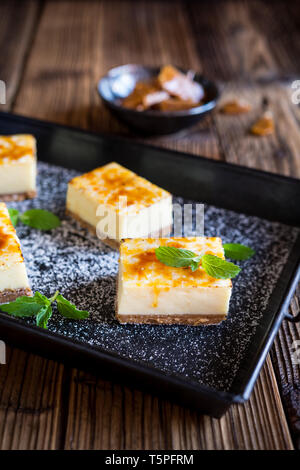 Homemade Creme Brulee cheesecake bars with cream cheese, crushed cookies, topped with caramelized sugar Stock Photo