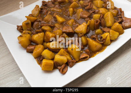 squid stew with potatoes on a white plate Stock Photo