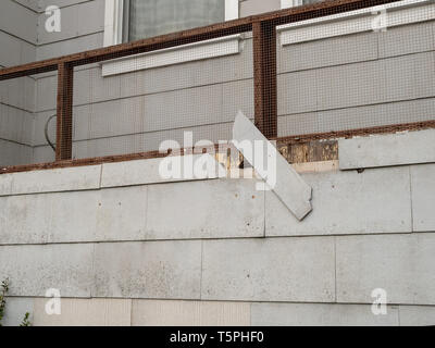Shingle on exterior wall of house falling off in state of disrepair Stock Photo