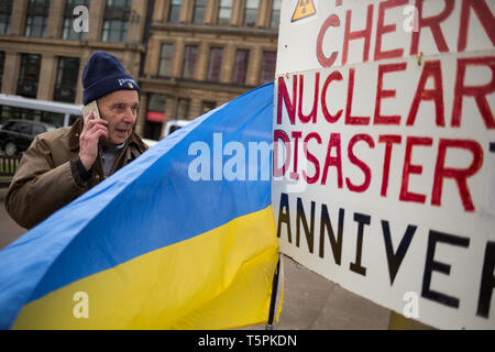 Glasgow, Scotland, 26th April 2019. 78-years old Jim Gillies stands in George Square with his placard remembering the 1986 Chernobyl nuclear disaster in the Ukraine. Today marks the 33rd anniversary of the disaster and Jim Gillies has marked the disaster day, by standing with his placard in the Square ever year since, as well as donating more than £20,000 GBP to a hospital in Ukraine, a country he has now visited approximately 20 times. Credit: jeremy sutton-hibbert/Alamy Live News Stock Photo