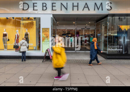 London, UK. 26th Apr 2019. Consumers pass by Debenhams Oxford Street. Debenhams names 22 store it will close by 2020. It seems its flagship store on Oxford Street is not one of them. Credit: Guy Bell/Alamy Live News Stock Photo