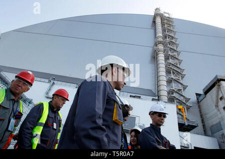 Workers are seen walking in front of the New Safe Confinement covering the 4th block of the Chernobyl Nuclear power plant during the anniversary. Ukrainians marked the 33rd anniversary of Chernobyl catastrophe. The explosion of the fourth block of the Chernobyl nuclear plant on 26 April 1986 is still regarded as the biggest accident in the history of nuclear power generation. Stock Photo