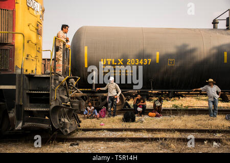 Ciudad Ixtepec, Mexico. 26th Apr, 2019. Migrants from Central America who are on their way to the USA are waiting at Ciudad Ixtepec station to take the train 'La Bestía'. The freight train will initially travel towards the Mexican state of Veracruz. Every year hundreds of thousands of people flee violence and poverty in Central America and try to reach the United States. Credit: Francisco García/dpa/Alamy Live News Stock Photo