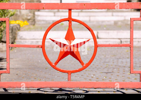 Red metal star in circle. Red army star symbol forged in metal gate to Russian military cemetery. Katowice Poland Stock Photo