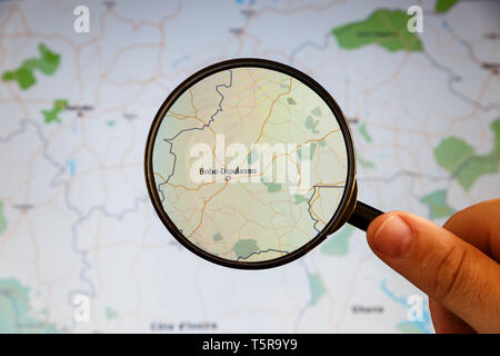 Bobo-Dioulasso, Burkina Faso. Political map. City visualization illustrative concept on display screen through magnifying glass in the hand. Stock Photo