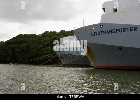 river fal above king harry ferry, with several huge car transporter ships laid up on moorings in the river Stock Photo