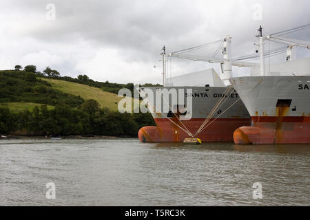 river fal above king harry ferry at tolverne, with two huge freighters laid up on moorings in the river Stock Photo