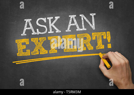 hand writes ASK AN EXPERT on blackboard Stock Photo