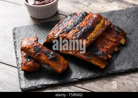 Grilled barbecue ribs on wooden table Stock Photo