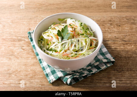Coleslaw salad in white bowl on wooden table. Stock Photo