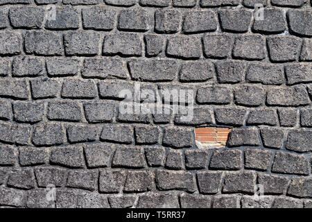 Building wall with uneven brick stones. Repair concept Stock Photo