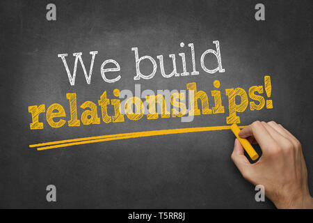 hand writes on chalkboard - We build relationships! Stock Photo