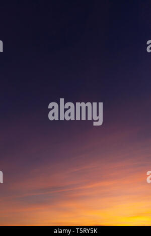 Sunset sky and wispy clouds. Orange and yellow light on clouds Stock Photo