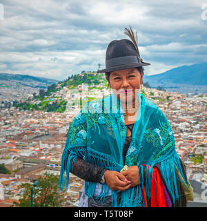 Portrait of a smiling indigenous Otavalo textile saleswoman in front of the historic city center of Quito in the Andes mountain range, Ecuador. Stock Photo