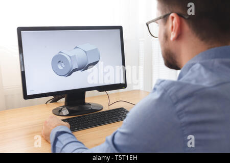 Engineer, Constructor, Designer in Glasses Working on a Personal Computer. He is Creating, Designing a New 3D Model of Mechanical Component in CAD Pro Stock Photo