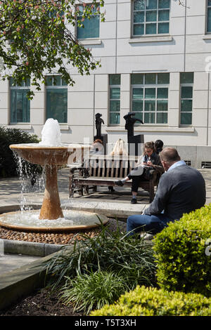 City workers taking a lunch break in a small London square. London UK. Stock Photo