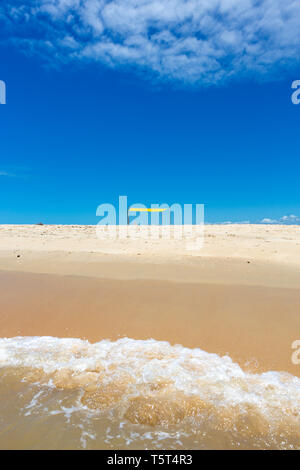 Beautiful beach view from sea point of view and small yellow tent on sunny summer day. Concept of vacations, peace and relaxation. Bahia, Brazil. Stock Photo