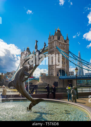View of the 'Girl with a Dolphin' sculpture and fountain by David Wynne on the waterfront next to Tower Bridge in London, UK on a sunny day. Stock Photo
