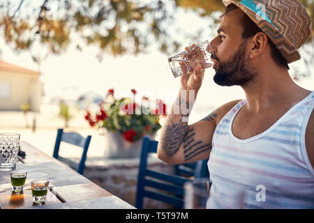 Young man hipster relaxes and drinking on vacation Stock Photo