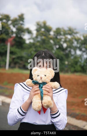 photo of a girl using a teddy bear to cover her face Stock Photo