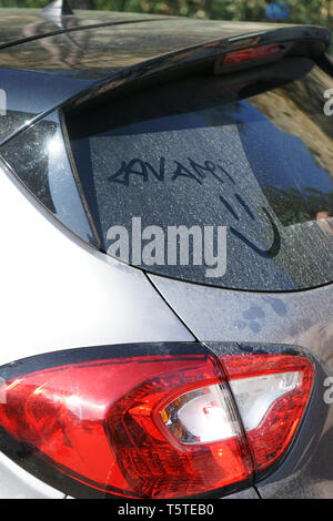 A Wash Me Please inscription in Italian language, written on the rear windowscreen of a dirty car Stock Photo