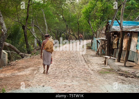 A fisherman walks home along the banks of the Rupsha River in Khulna, Bangladesh, after a day spent catching fish. Stock Photo