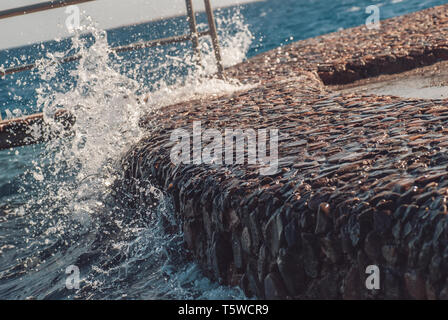 Giant Ocean waves hitting stone pier during storm. Vacation summer fresh picture Stock Photo