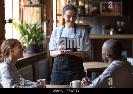 Waitress welcoming restaurant guests take order writing on notepad Stock Photo