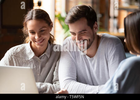 Diverse people sitting indoors watching something interesting on laptop Stock Photo