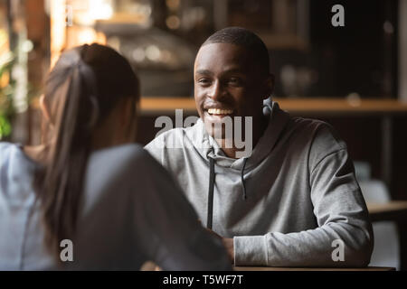 Black cheerful guy chatting with girl during speed dating Stock Photo