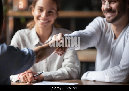 Millennial cheerful business people shaking hands sitting indoors Stock Photo