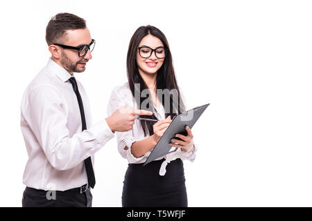 Couple of colleagues wearing formal clothing standing isolated over white background, working together, holding binder Stock Photo