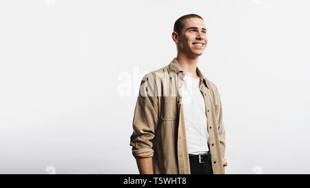 Portrait of smiling man isolated on white background. Young man wearing an unbuttoned shirt looking away. Stock Photo