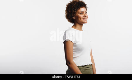 Side view portrait of smiling young woman isolated on white background. Woman with curly hair having a pleasant smile. Stock Photo