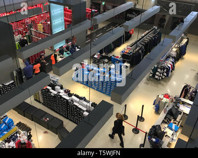 ATHENS, GREECE - FEBRUARY 22, 2019: People at the sportswear section of a shopping mall. Boxes with sneaker shoes and racks of clothes. Stock Photo