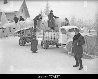 The Winter War. A military conflict between the Soviet union and Finland. It began with a Soviet invasion on november 1939 when Soviet infantery crossed the border on the Karelian Isthmus. About 9500 Swedish volunteer soldiers participated in the war. Here at Rovaniemi, North Finland. The unit called Lapland Group successfully stopped the Soviet troups,  though outnumbered, at Salla and Petsamo. Picture shows Finnish soldiers loading part of a Soviet aircraft that was shot down. January 1940. Photo Kristoffersson ref 99-3 Stock Photo