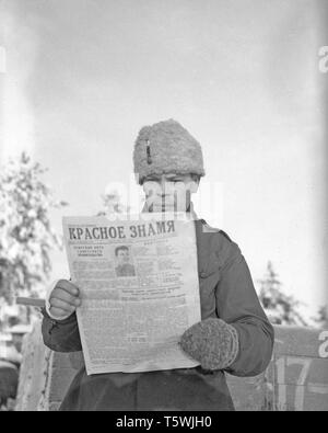 The Winter War. A military conflict between the Soviet union and Finland. It began with a Soviet invasion on november 1939 when Soviet infantery crossed the border on the Karelian Isthmus. About 9500 Swedish volunteer soldiers participated in the war. Here at Rovaniemi, North Finland. The unit called Lapland Group successfully stopped the Soviet troups,  though outnumbered, at Salla and Petsamo. Picture shows Finnish soldier reading a Soviet newspaper he found among personal belongings of Soviet soldiers. January 1940. Photo Kristoffersson ref 99-3 Stock Photo