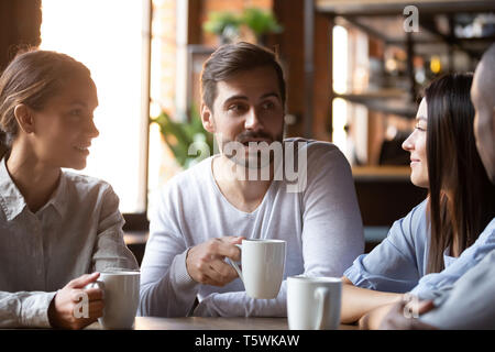 Diverse group of best friends sitting in cafe and chatting Stock Photo