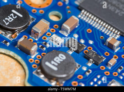 Macro closeup image of various SMT (Surface Mount Technology) components mounted on an electronics PCB (Printed Circuit Board). Stock Photo